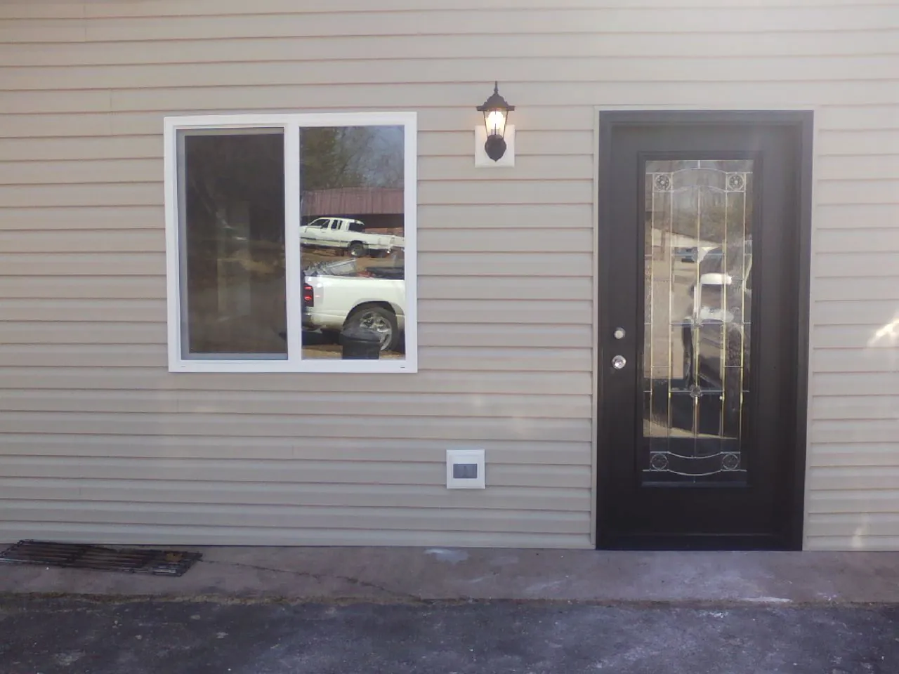 New siding, window and entry door on the side of an addition in Fort Sill