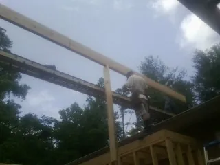 Carpenter setting a ridge beam over a new addition frame — Ice Dam Removal by Roofing Brothers in Fort Sill