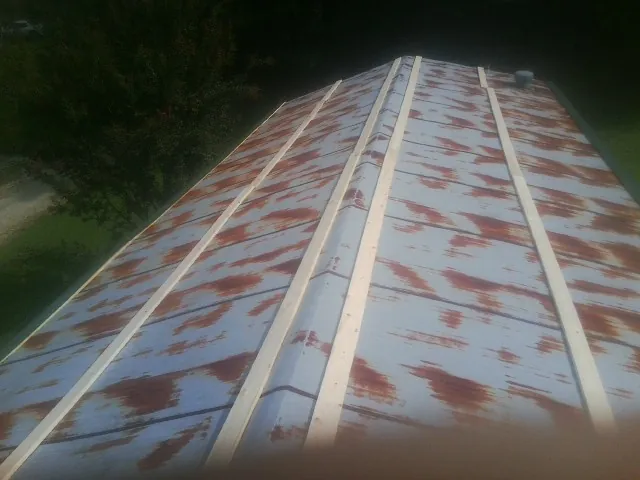 Rusted metal roof panels with new wood purlins before replacement — Storm Damage Roof Repair in Fort Sill by Roofing Brothers