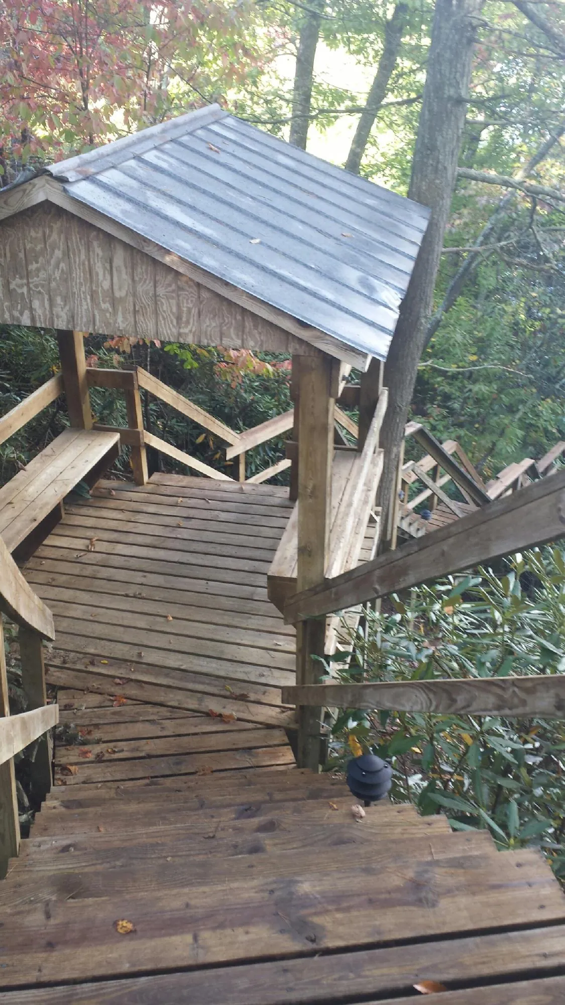 Metal roofed shelter over wooden steps on a wooded walkway — Skylight Repair & Installation work by our crew in Fort Sill