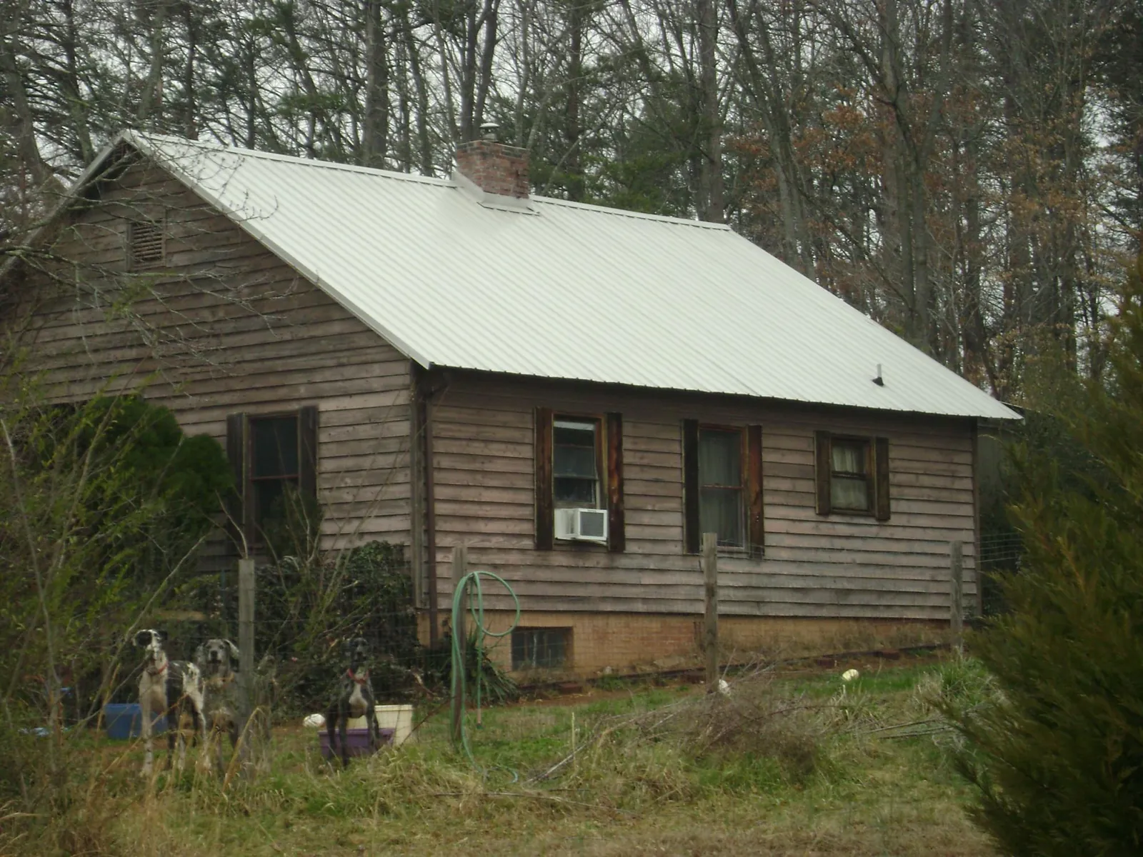 White metal roof on an old wood sided farmhouse, from a Metal Roof Installation job in Fort Sill
